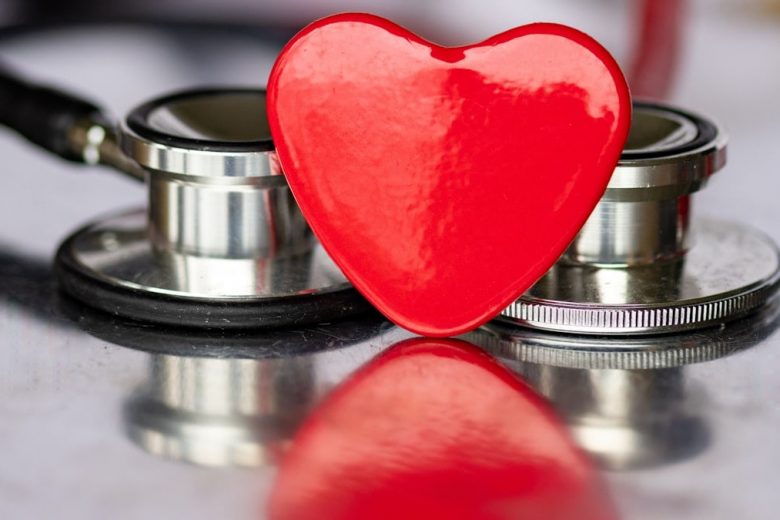a red heart sitting on top of a stethoscope
